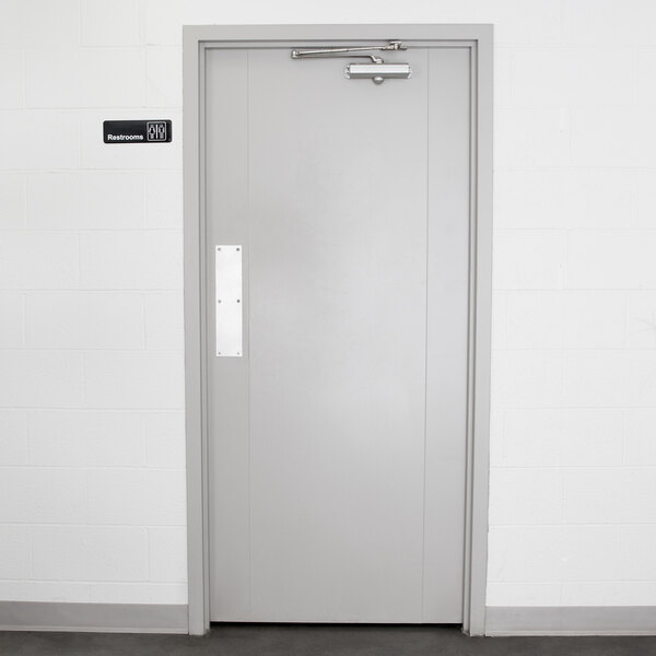 A white door with a rectangular black and white Vollrath Traex sign.