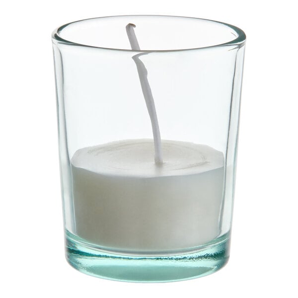 A white wax-filled votive candle in a clear glass holder.