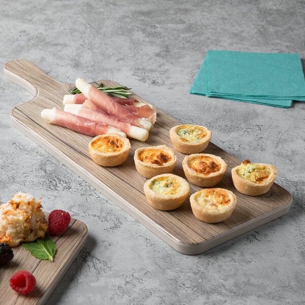 A Thunder Group Sequoia faux wood melamine serving board with appetizers on a table.