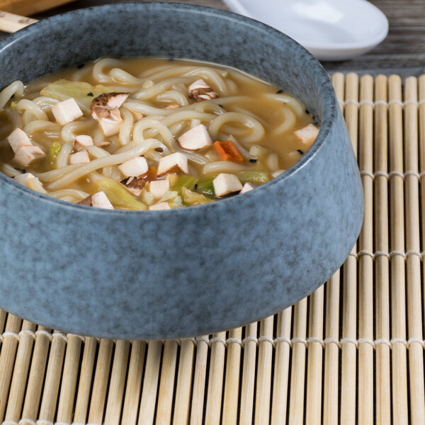 A blue Biseki stoneware bowl filled with noodles with chopsticks.