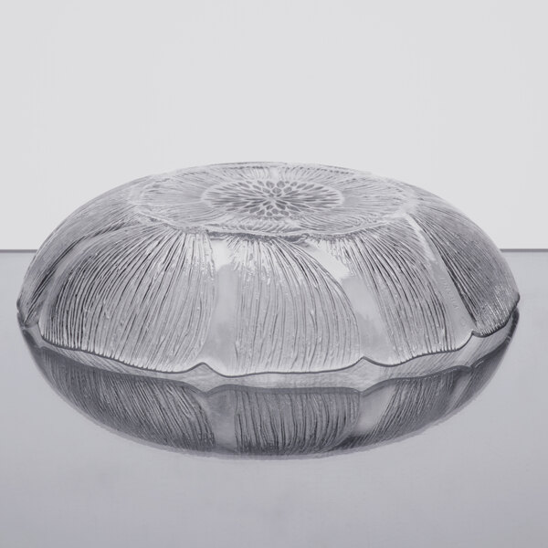 An Arcoroc glass compote bowl with a flower design on it.