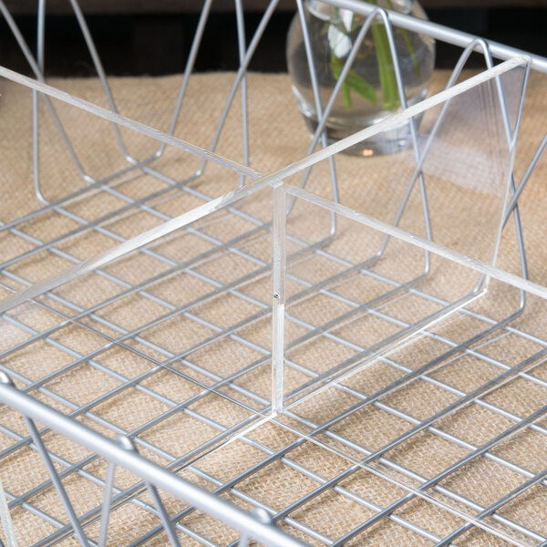 A Clipper Mill metal wire basket with clear plastic dividers inside.