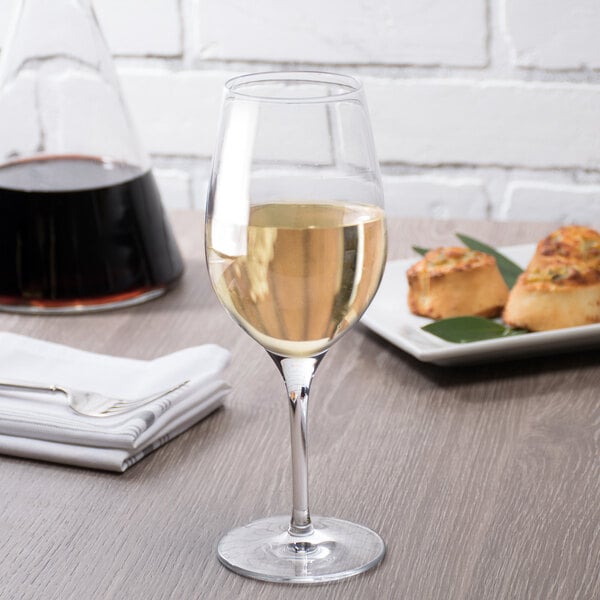 A Stolzle white wine glass full of white wine on a table