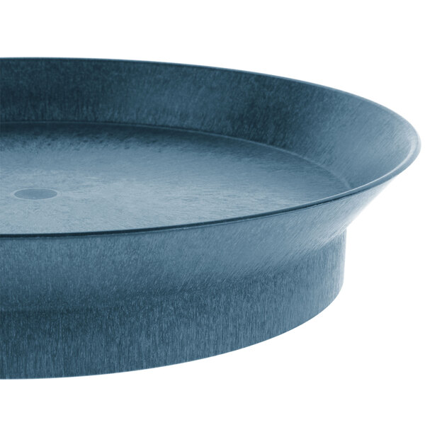 A close-up of a round blue polypropylene deli server with a circular rim.