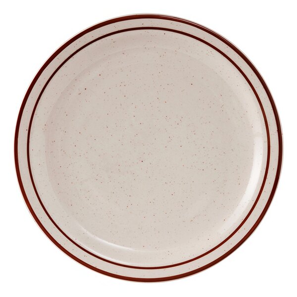 A close-up of a Tuxton white china plate with a brown speckled rim.