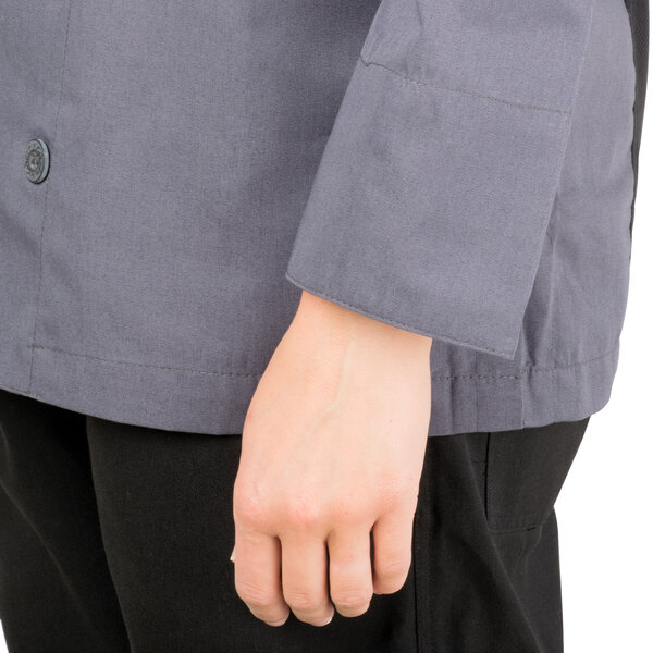 A person wearing a gray Chef Revival chef jacket with a mesh back.