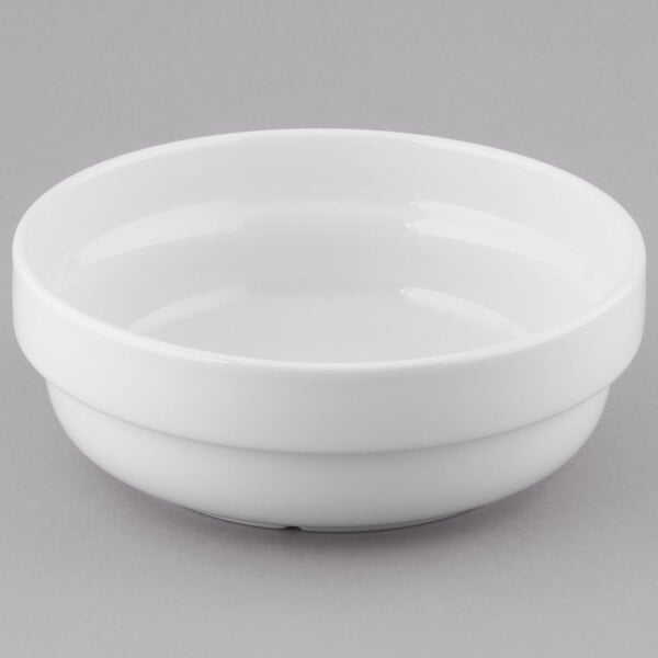 A stack of 12 Tuxton porcelain white salad bowls.