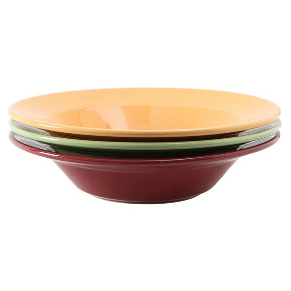 A stack of Tuxton pasta bowls in assorted colors on a white background.