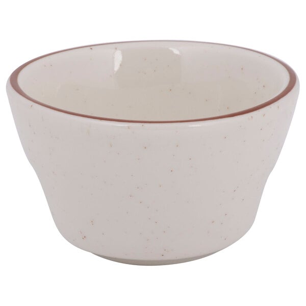 A white bowl with brown speckled rim.