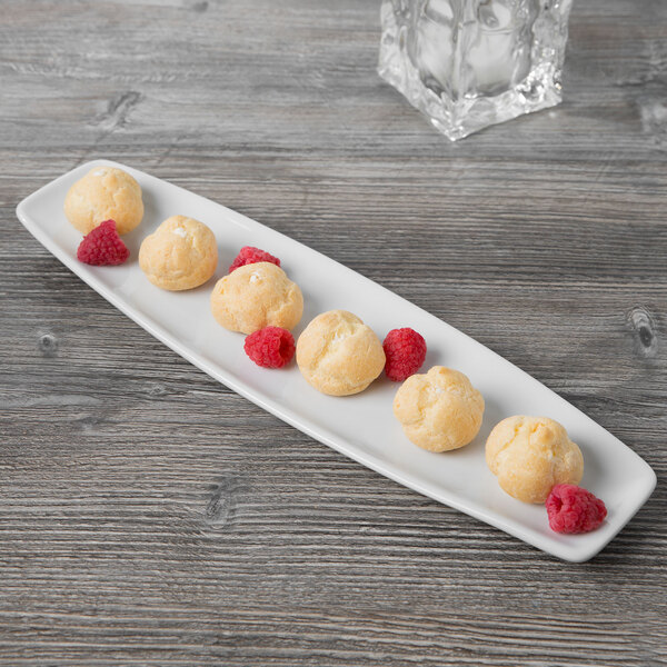 A Tuxton porcelain white rectangular china platter with food on it.