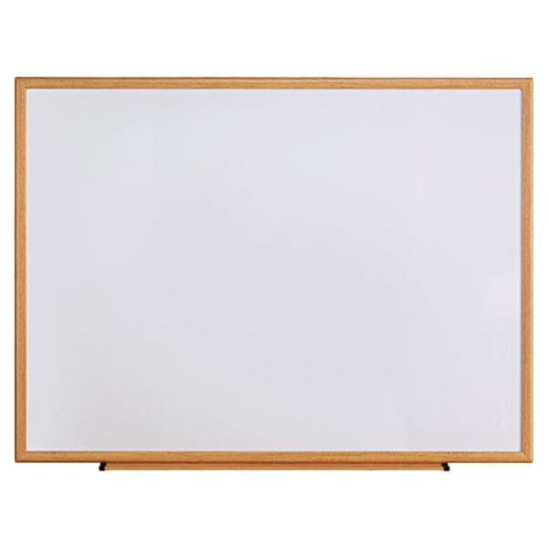 A Universal white melamine dry-erase board with an oak frame.