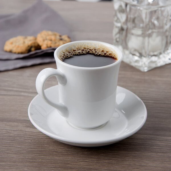 A Libbey Basics tall white porcelain cup of coffee on a saucer.