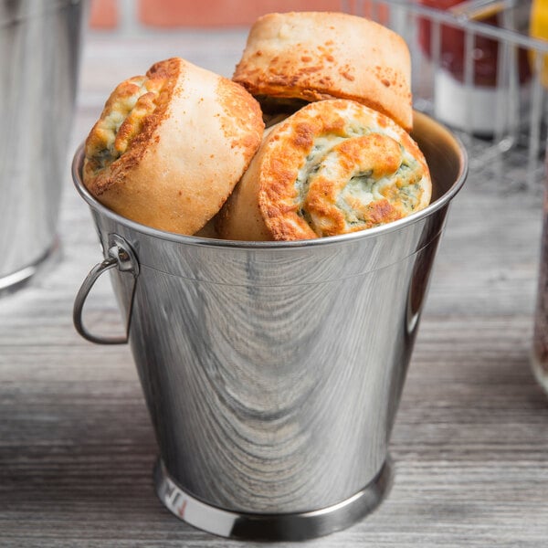 A Clipper Mill stainless steel serving pail filled with food on a table.