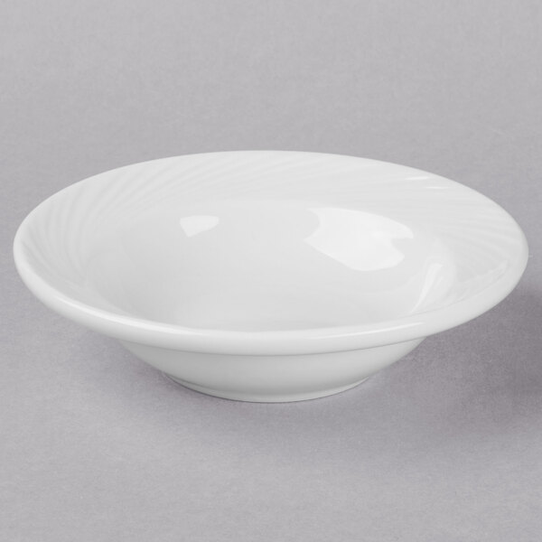 A Libbey Basics Orbis bright white porcelain fruit bowl with a rim on a white surface.