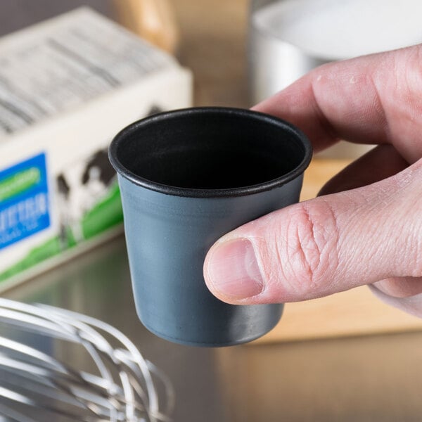 A person holding a Matfer Bourgeat rum baba mold.