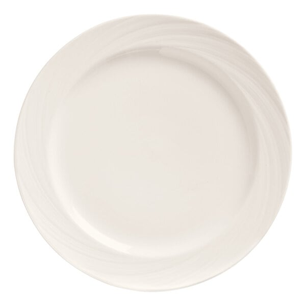 A close up of a Libbey bright white porcelain plate with swirls on the rim.