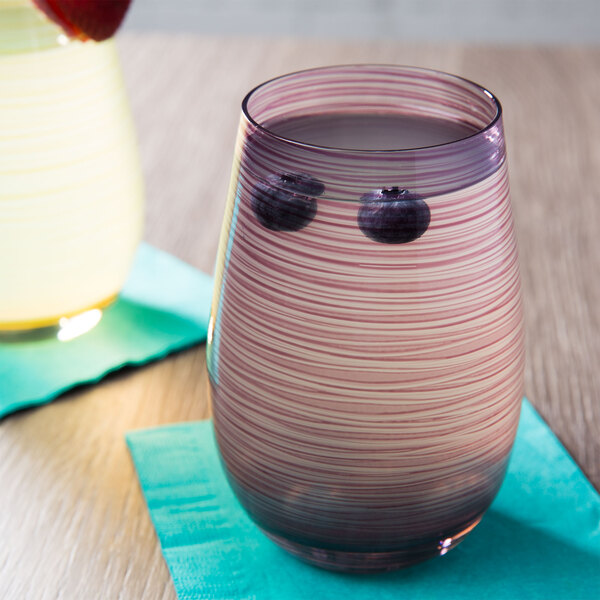 A Stolzle lilac stemless wine glass with blueberries in it.