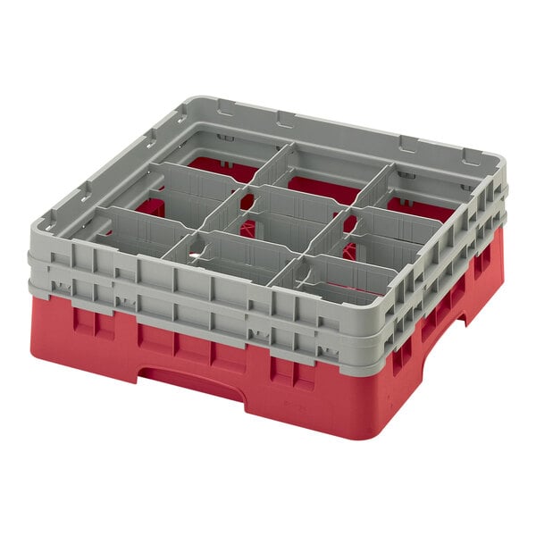A red plastic Cambro glass rack with 9 compartments and 2 grey extenders.