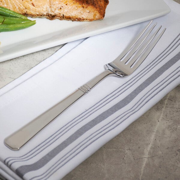 A Bon Chef stainless steel dinner fork on a plate with food.