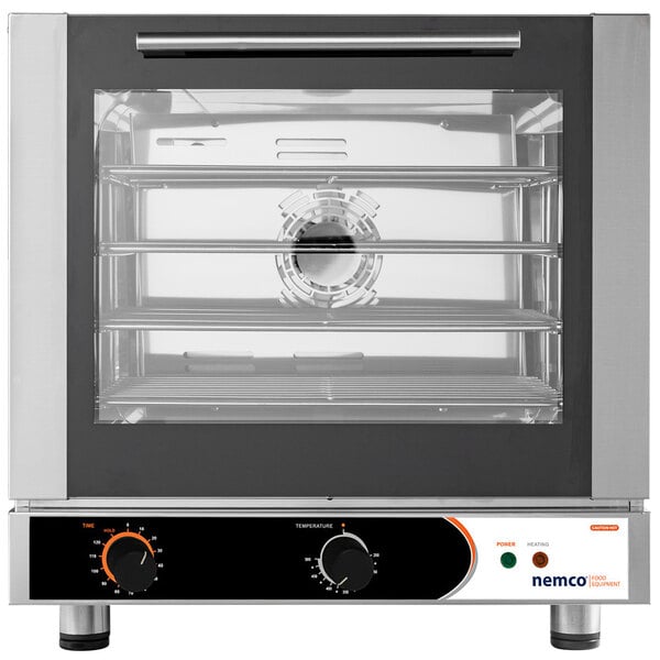 A Nemco countertop convection oven with two racks filled with food.