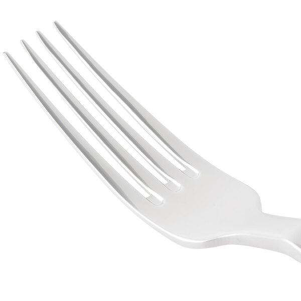 A close-up of a Bon Chef stainless steel dinner fork with a white handle.