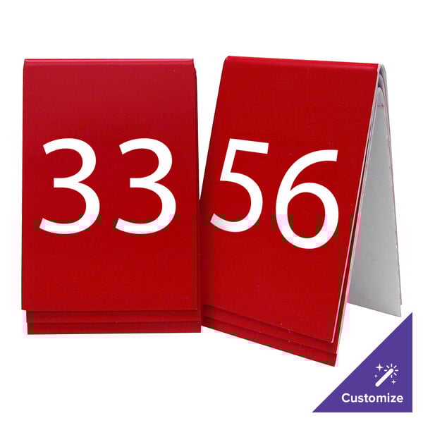 Two red Cal-Mil customizable table number tent signs with white numbers.