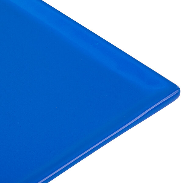 A close-up of a cobalt blue Tablecraft cast aluminum rectangular cooling platter.
