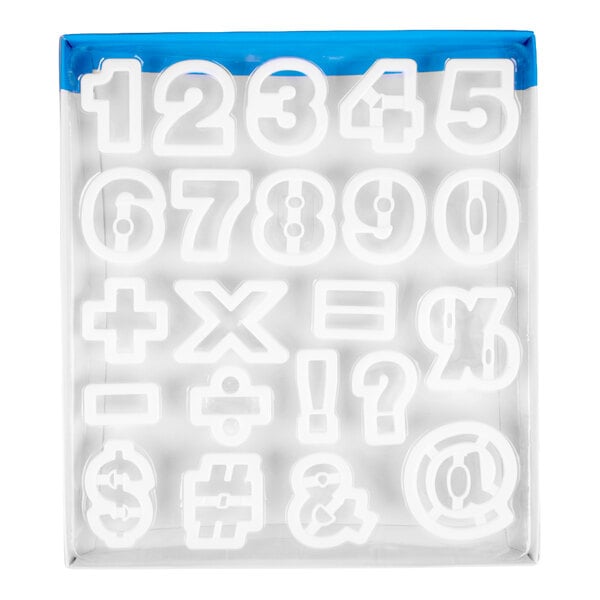 A set of white plastic cutters in the shapes of numbers and various mathematical and punctuation symbols, arranged in a box.