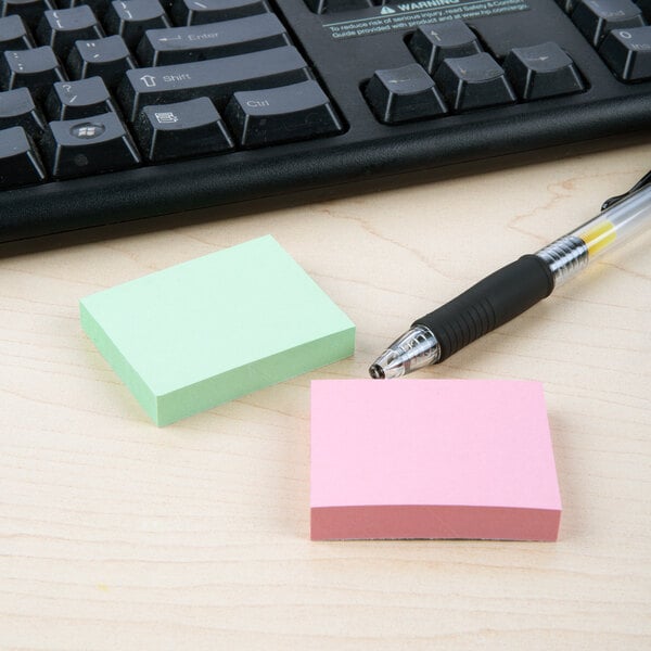 Redi-Tag assorted color self-stick notes and a pen on a desk.