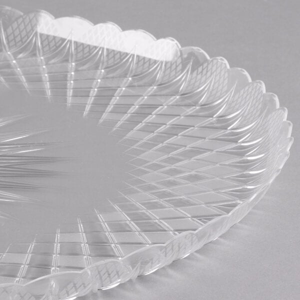 A clear plastic Fineline Catering Tray with a scalloped edge.