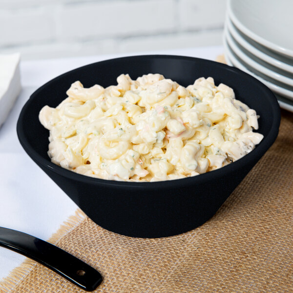 A Tablecraft round cast aluminum serving bowl with a blue speckled interior and a black handle filled with macaroni salad.