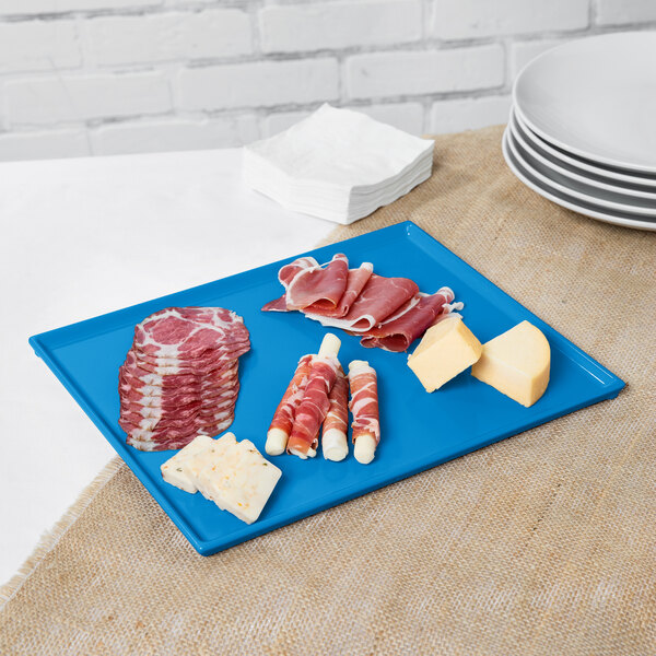 A Tablecraft sky blue cast aluminum rectangular cooling platter holding meat and cheese.