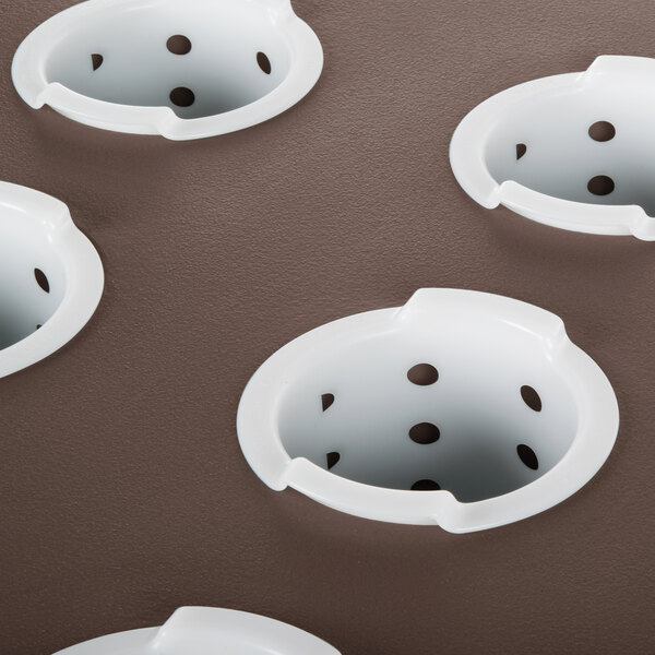 A dark brown Cambro cutlery rack with holes for utensils.