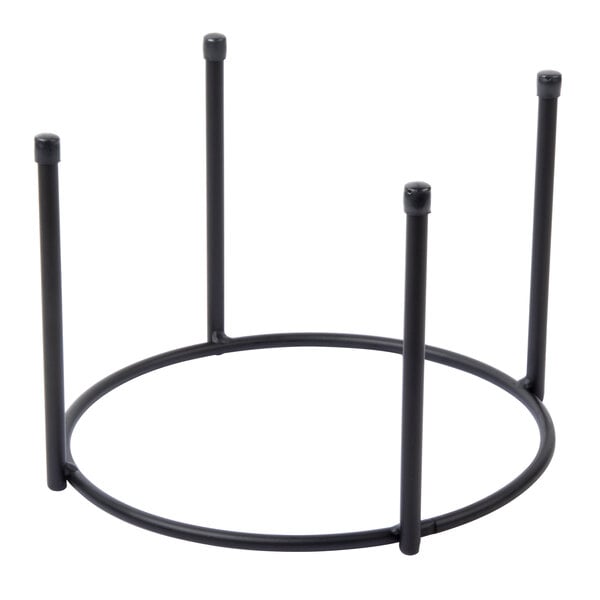 A Clipper Mill black iron round pizza stand with three legs.