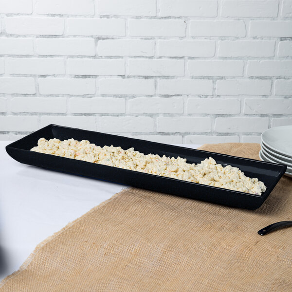 A black rectangular tray with food on it.