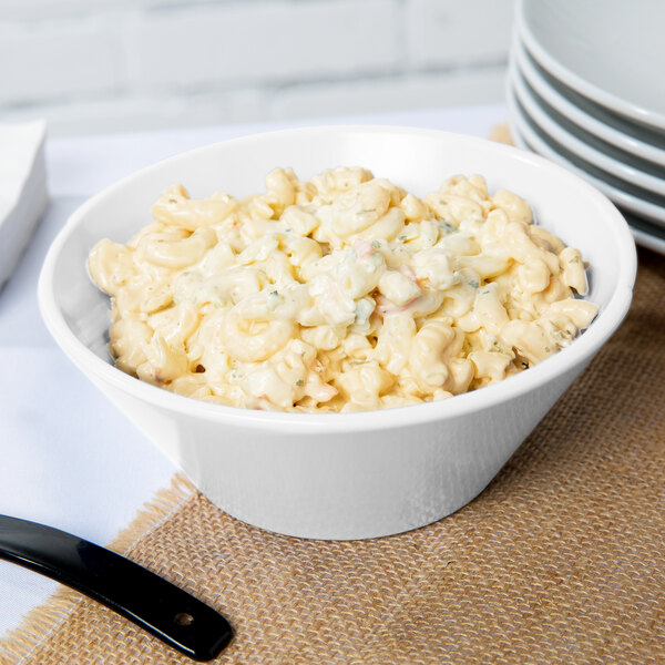 A Tablecraft white cast aluminum serving bowl filled with macaroni salad.