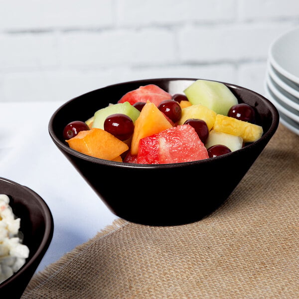 A Tablecraft Midnight Speckle cast aluminum serving bowl filled with fruit salad on a table.