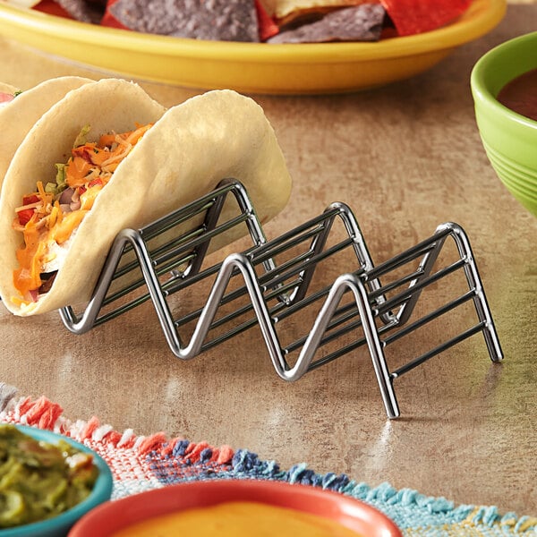 A Clipper Mill stainless steel taco holder with tacos in it.