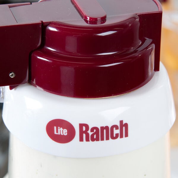 A white plastic Tablecraft salad dressing dispenser collar with maroon lettering and a red lid.