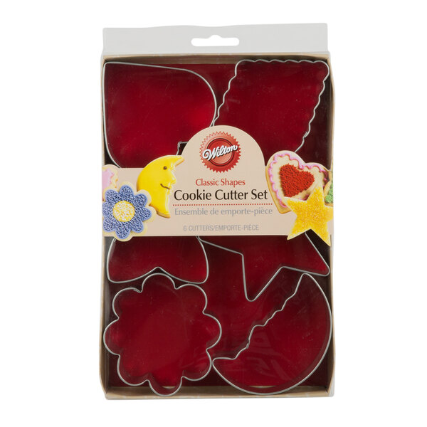A red box of Wilton 6-Piece Metal Basic Shapes Cookie Cutters on a bakery counter.
