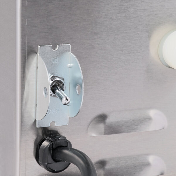 A Curtis low profile tea brewer in a stainless steel sink.