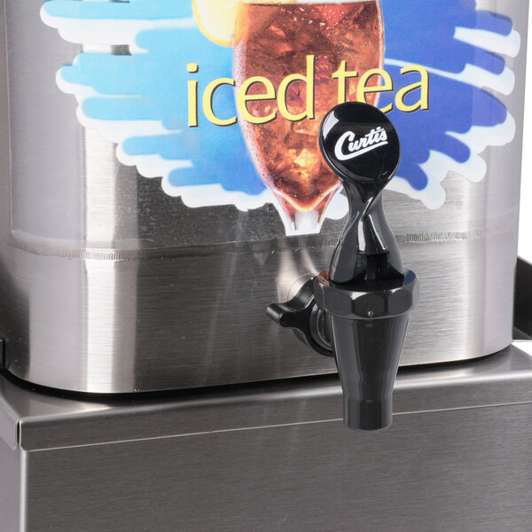 A black Curtis tea dispenser on a metal surface.