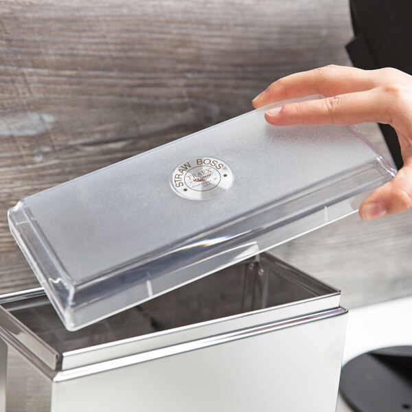 A hand holding a clear plastic lid.