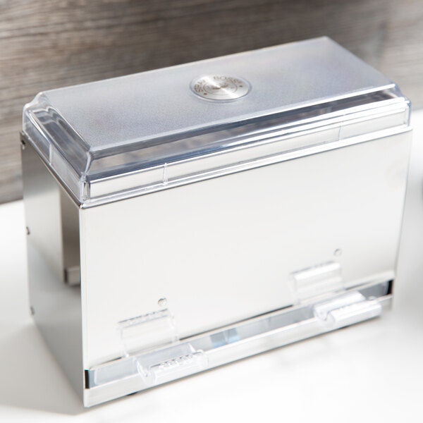 A silver Vollrath straw dispenser lid with a clear lid on top of a counter.