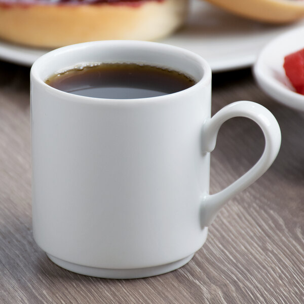 A Schonwald white porcelain cup filled with coffee on a table.