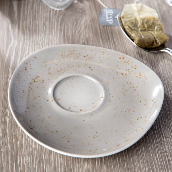 A light gray Schonwald porcelain saucer with a unique speckled design.