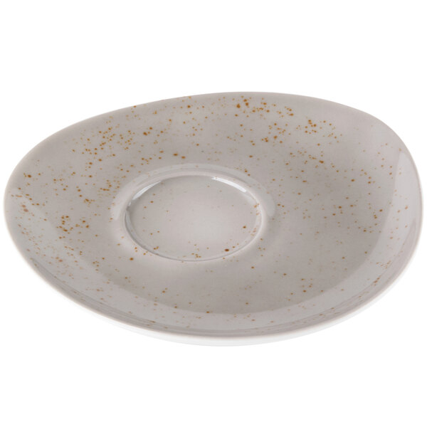 A light gray Schonwald porcelain saucer with brown speckled spots on it.