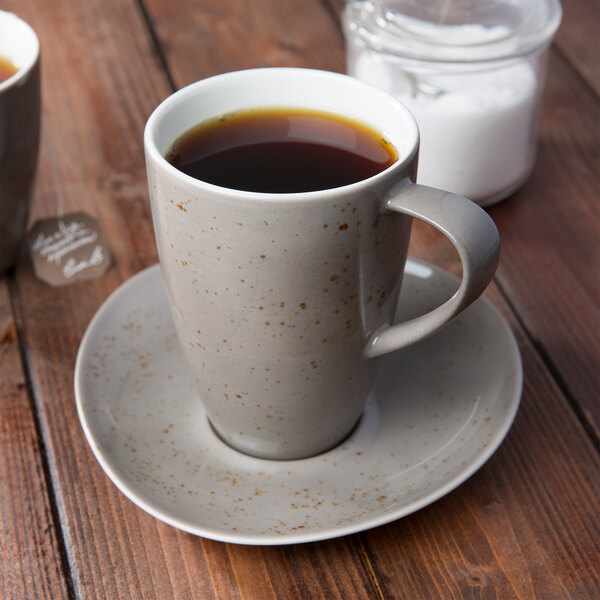 A cup of coffee on a Schonwald light gray porcelain saucer.