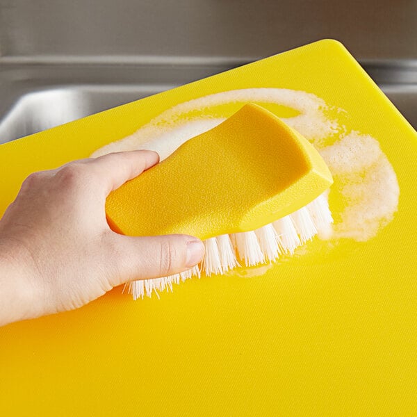 a hand holding a yellow sponge