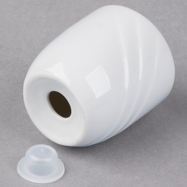 A Schonwald white porcelain pepper shaker with a plastic cap.